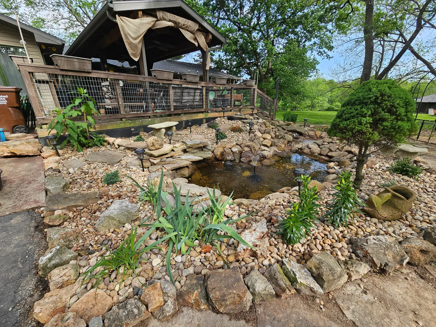 Custom backyard water feature with stacked-stone waterfall